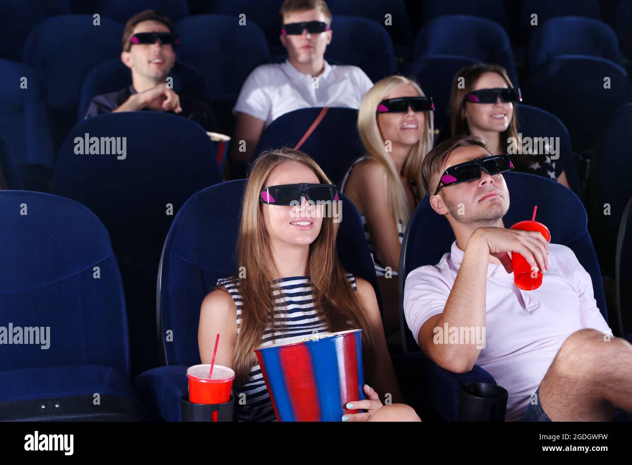 Young people watching movie in cinema Stock Photo - Alamy