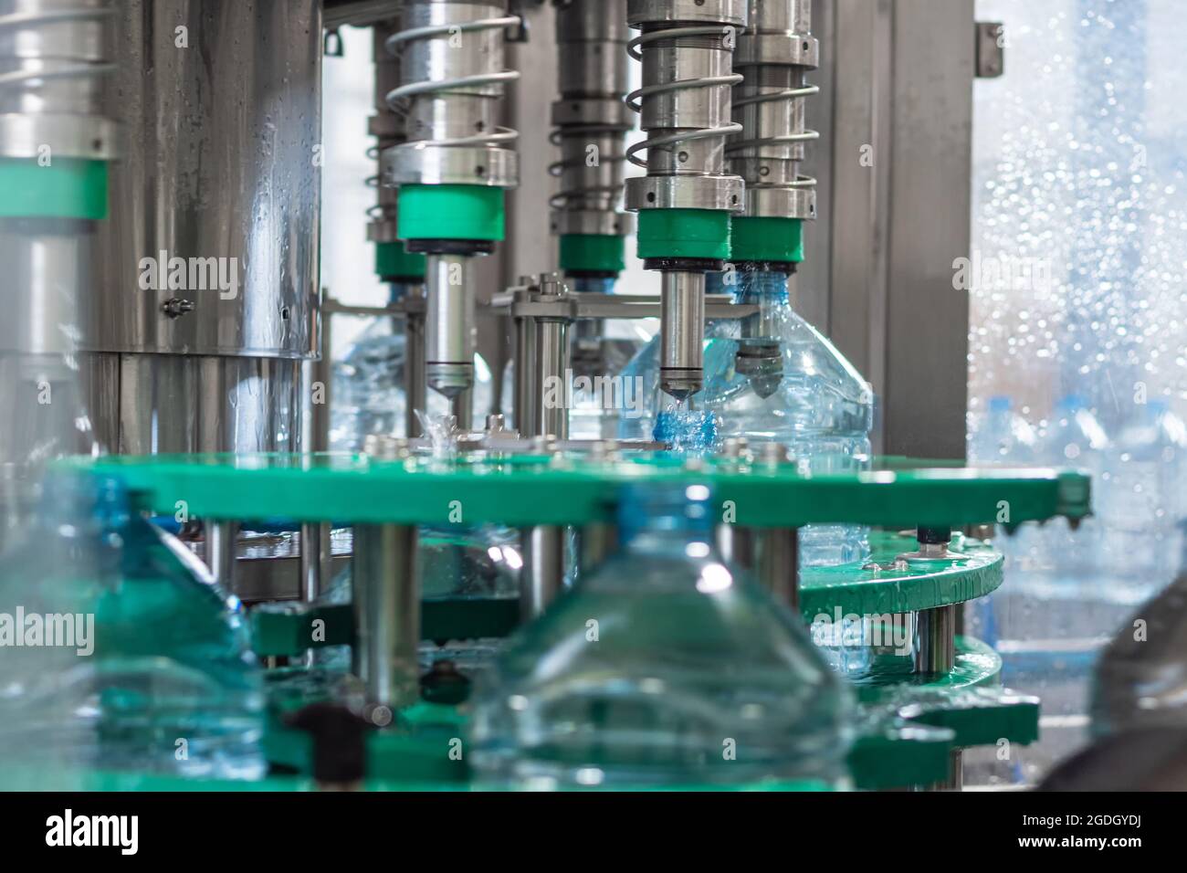 Automatic bottling drinking water in five-liter plastic bottles. Food production Stock Photo