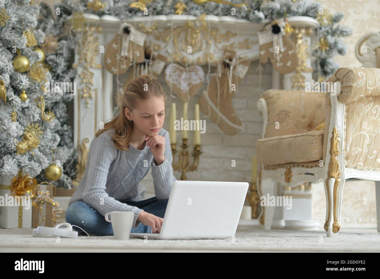 Teenage girl with laptop on floor on Christmas Stock Photo - Alamy