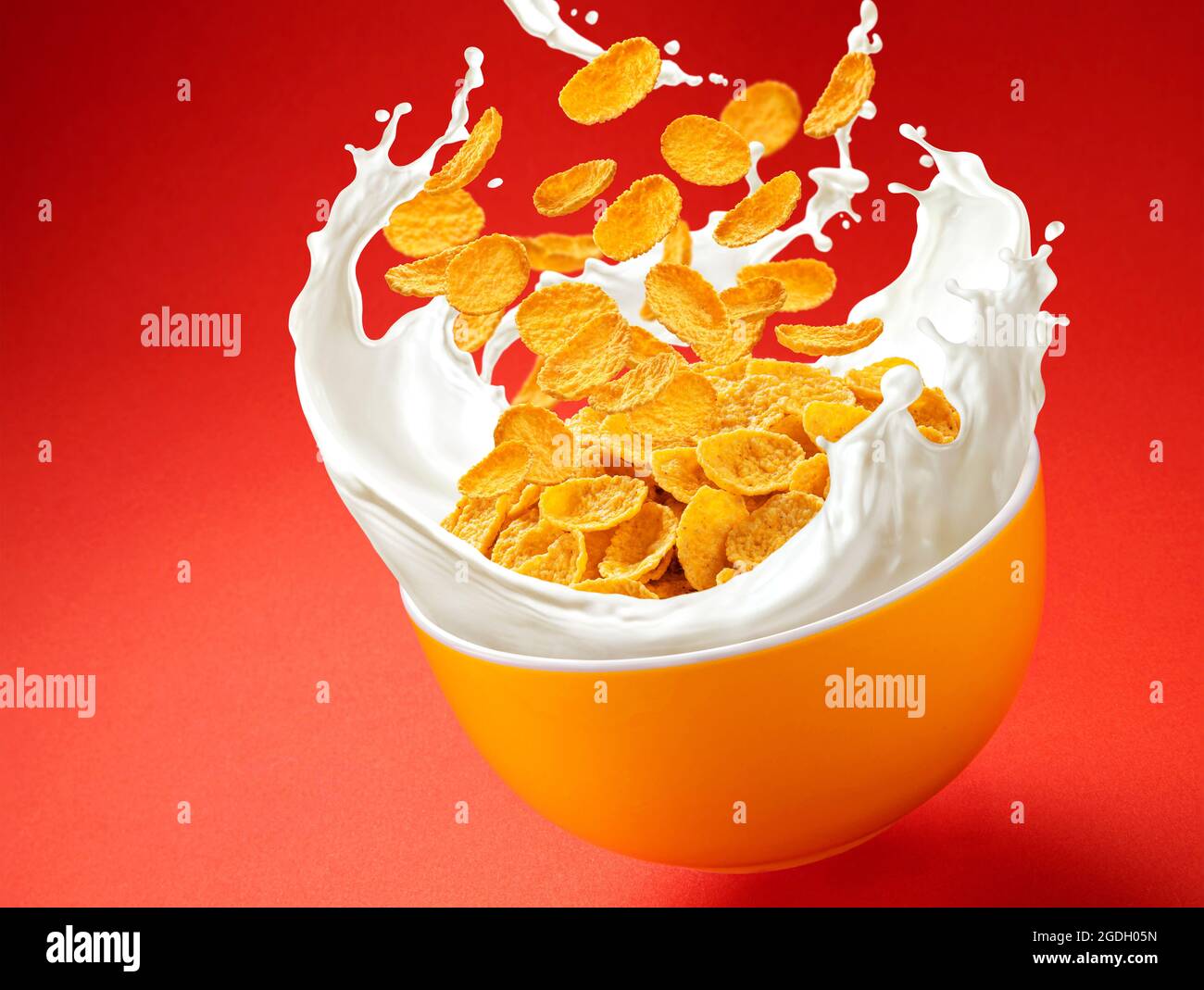 Corn flakes with milk splashes on red background Stock Photo