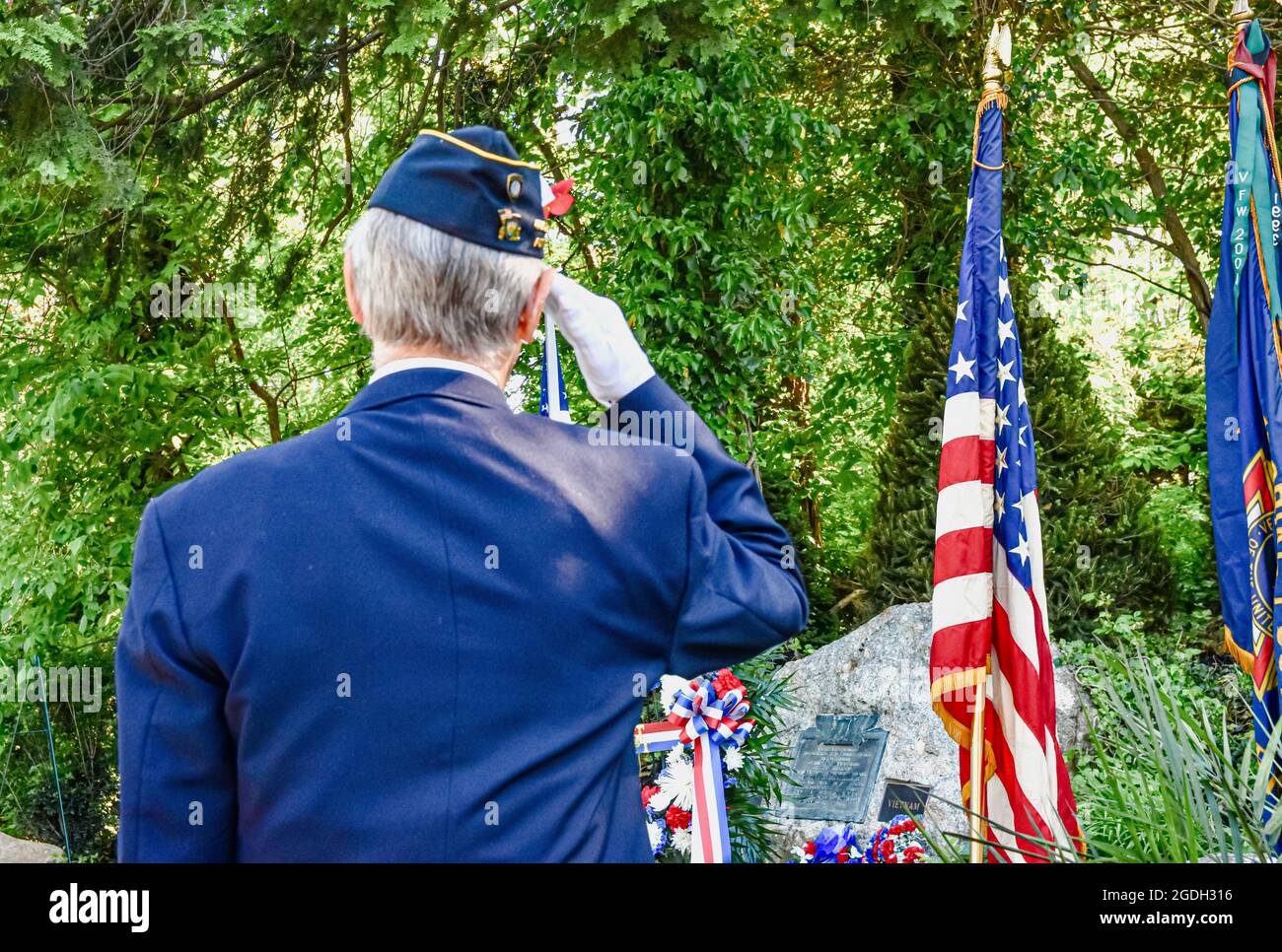 Veteran paying tribute to the fallen with a salute to the veterans war memorial. Close-up Stock Photo