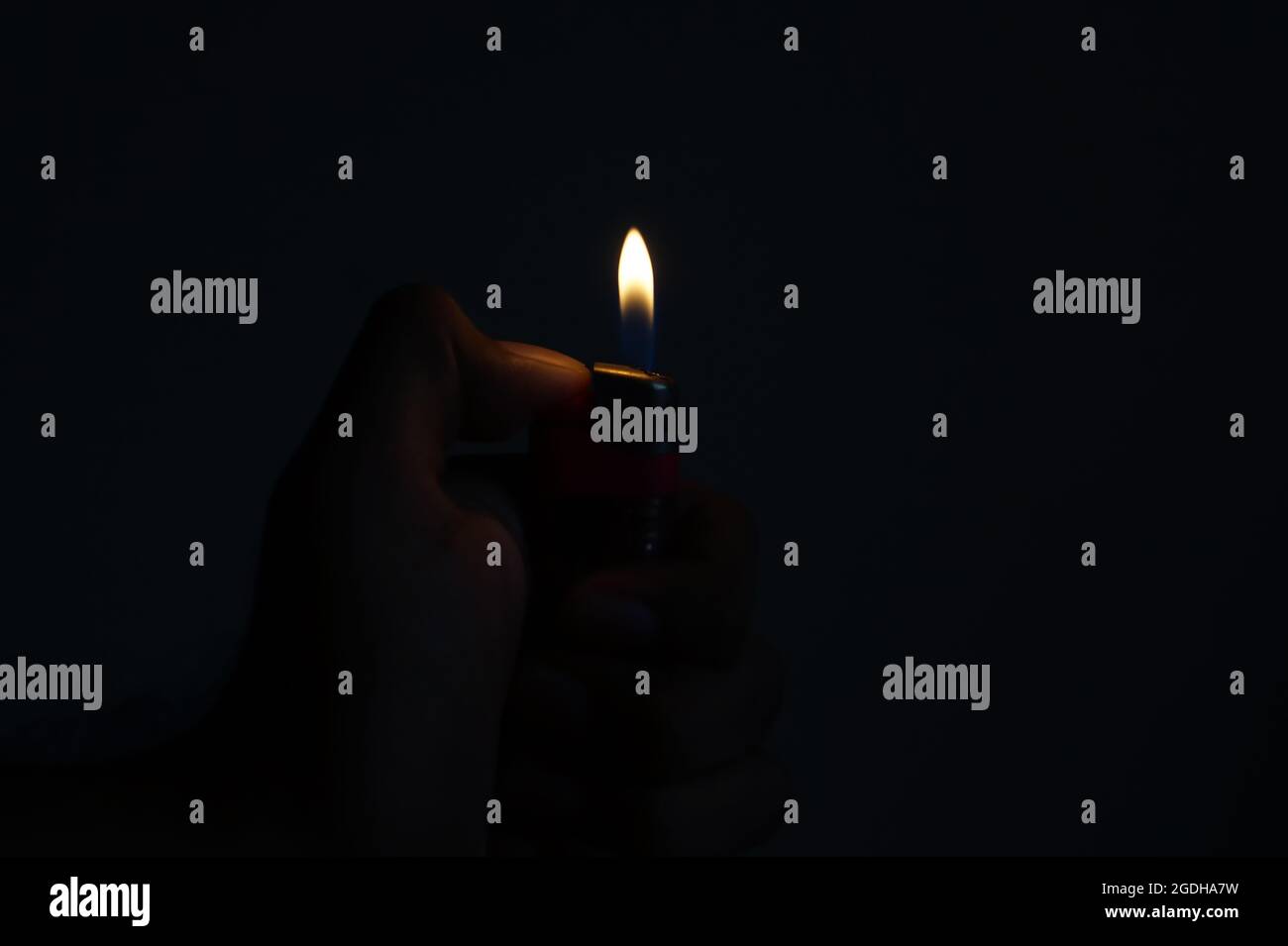 Cigarette Lighter in the hand on a dark background Stock Photo