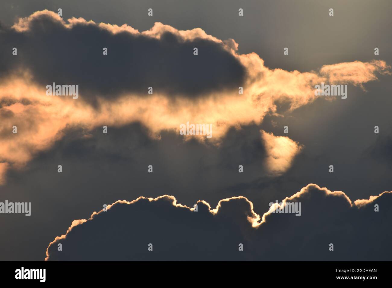 Evening sun behind dark clouds Stock Photo