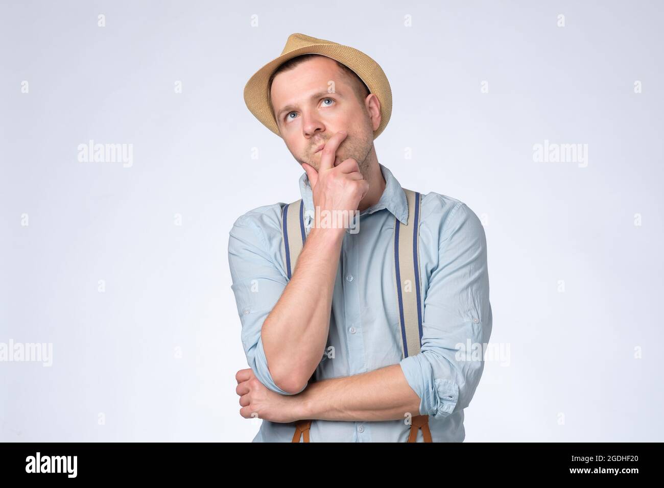 Young thoughtful man looking up generating idea, making plans for future. Stock Photo