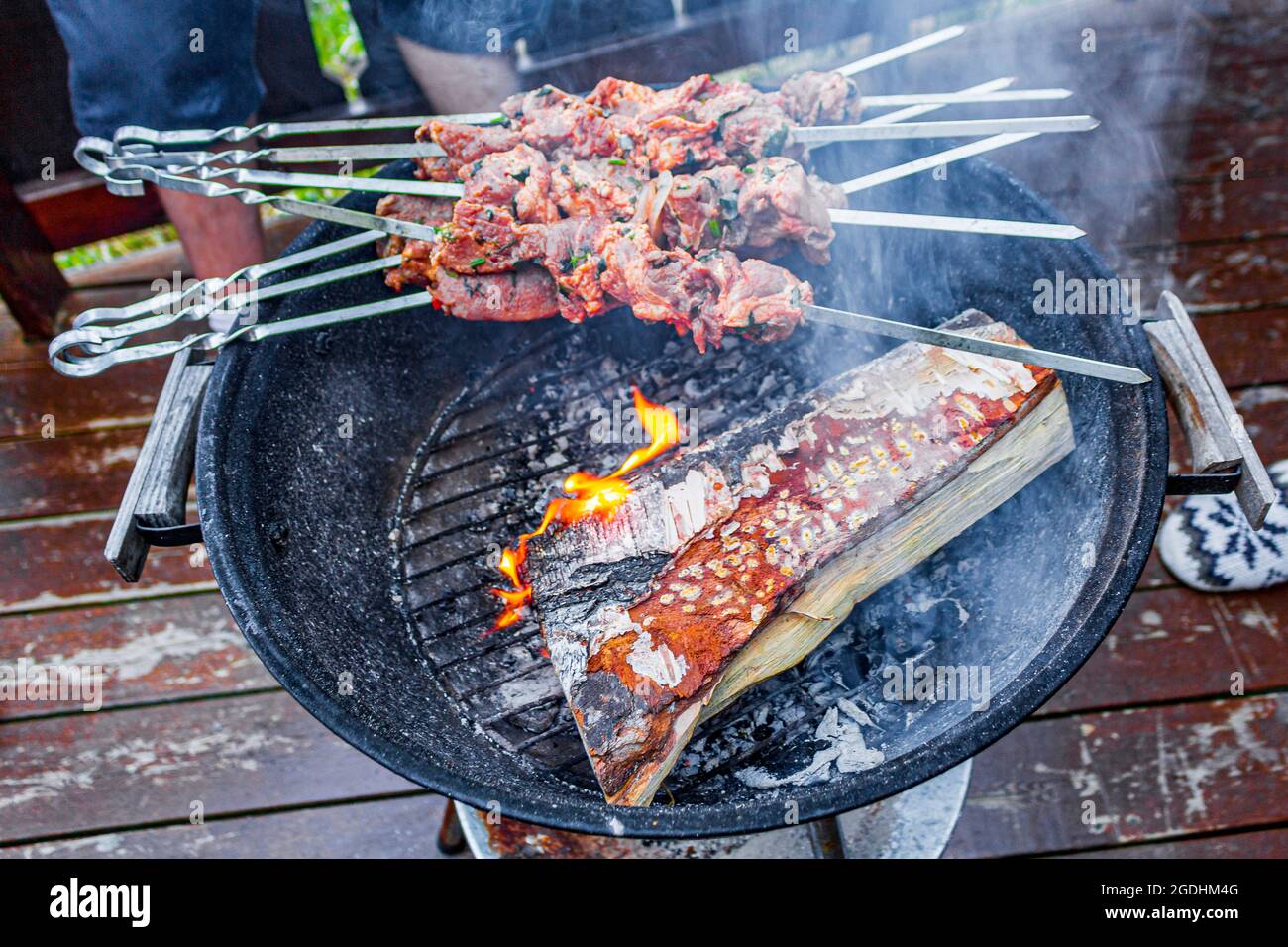 Russian shashlik barbecue on birch wood with skewers on a round grill in  Norway Stock Photo - Alamy