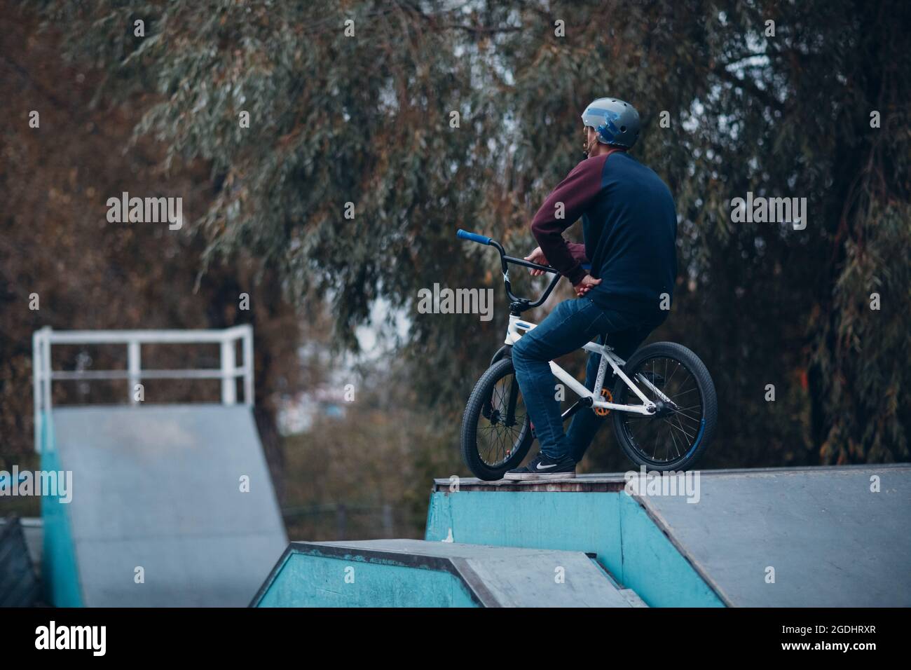 Professional young sportsman cyclist riding mini bike at skatepark Stock Photo