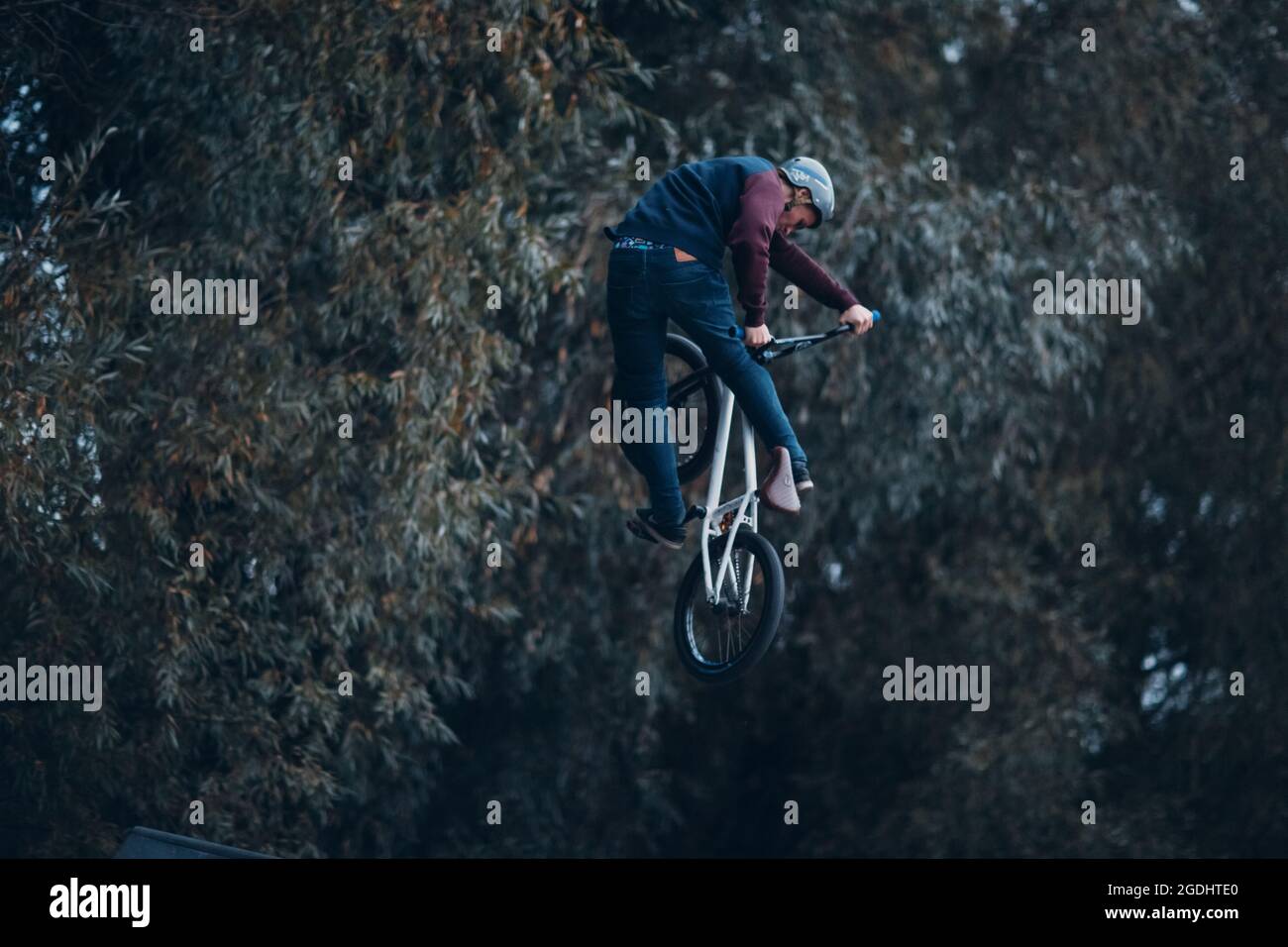 Professional young sportsman cyclist riding mini bike at skatepark Stock Photo