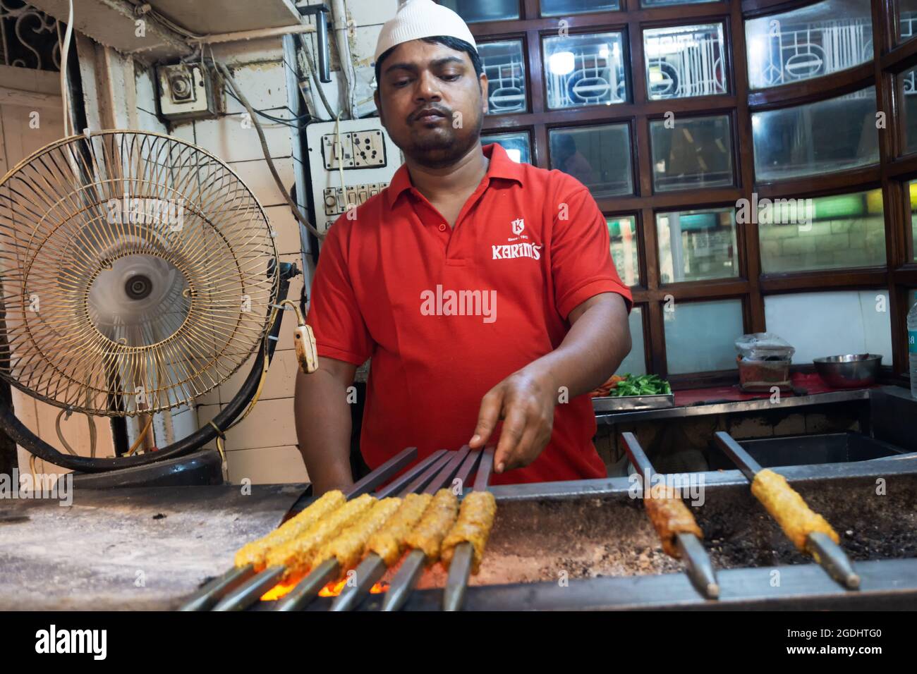 Old Delhi, India - March 4, 2018: Unidentified Man grilling an Indian Chicken and Mutton Kebabs at Chandni Chowk in Old Delhi India Stock Photo