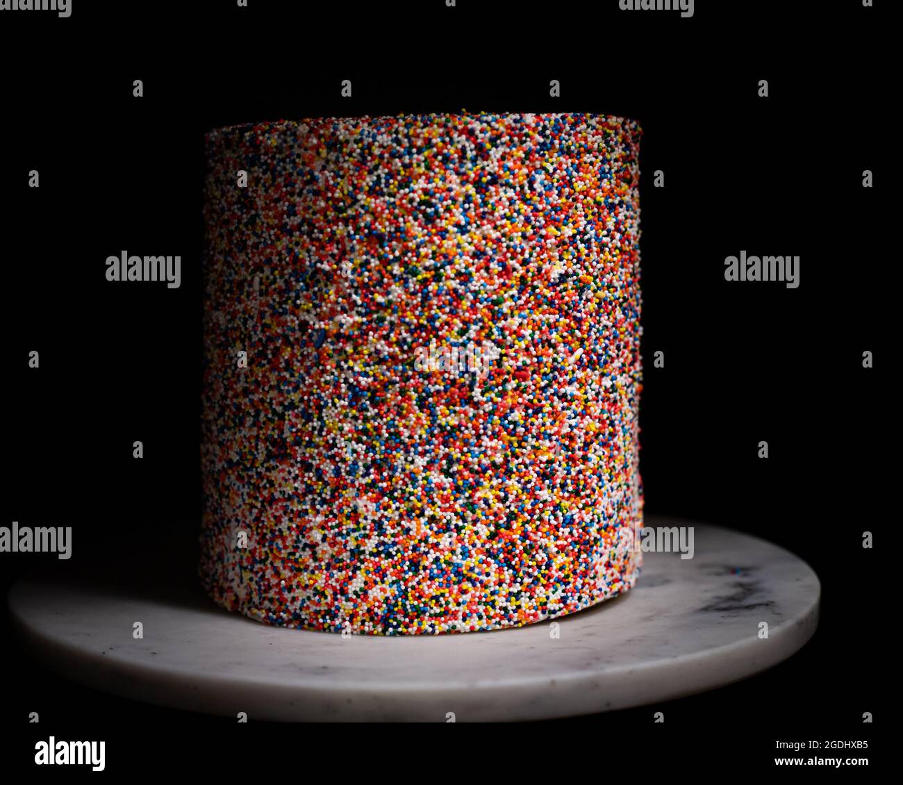 rainbow sprinkle cake on white marble Stock Photo