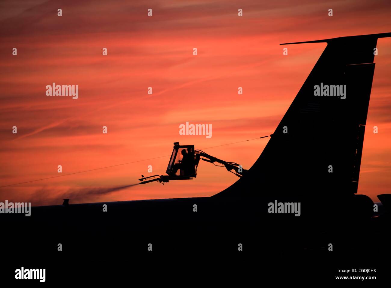 Tech. Sgt. Joshua Nordeen, Pennsylvania Air National Guard, de-ices an aircraft early in the morning as the sun rises in Pittsburgh, Dec. 12, 2019. (U.S. Air National Guard photo by Staff Sgt. Bryan Hoover) Stock Photo