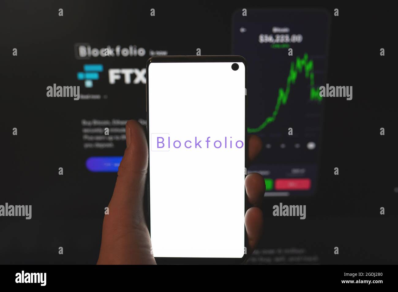 Blockfolio logo on smartphone in hand with blurred website background. Cryptocurrency exchange, crypto portfolio tracker platform. Swansea, UK - July 31, 2021 Stock Photo