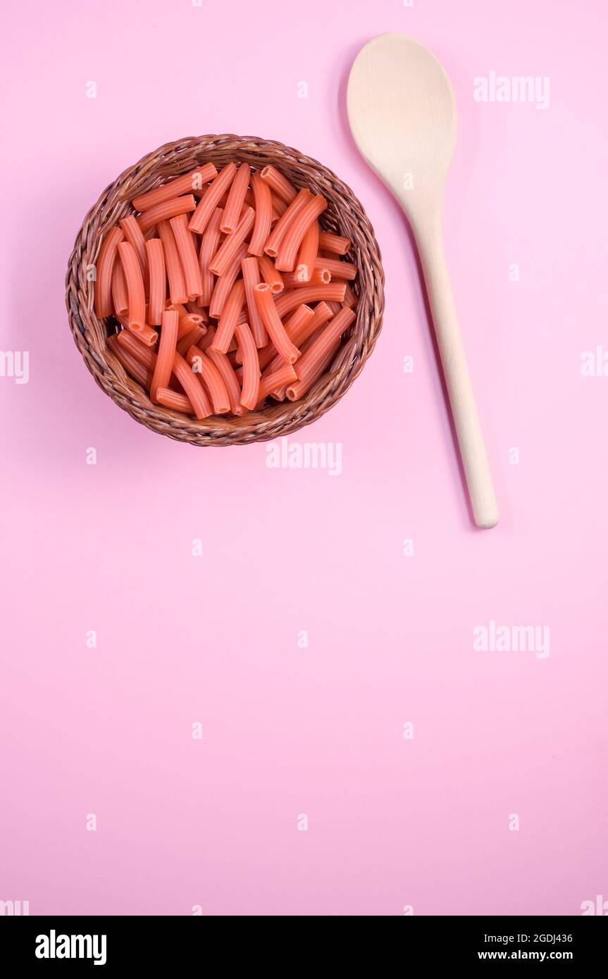 Vertical shot of macaroni with a spoon on a light pink background Stock Photo Alamy