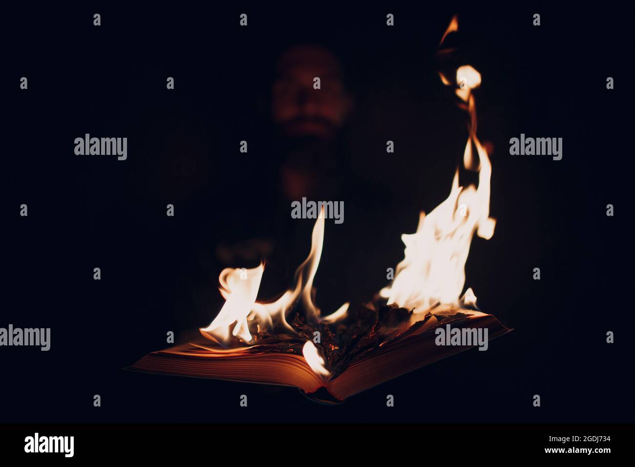 Man hold burning book in his hands Stock Photo