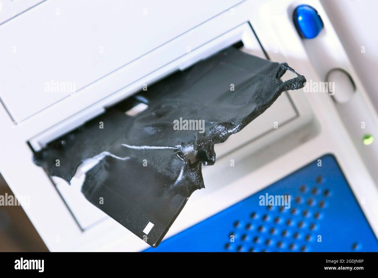melted and broken floppy disk in a drive Stock Photo