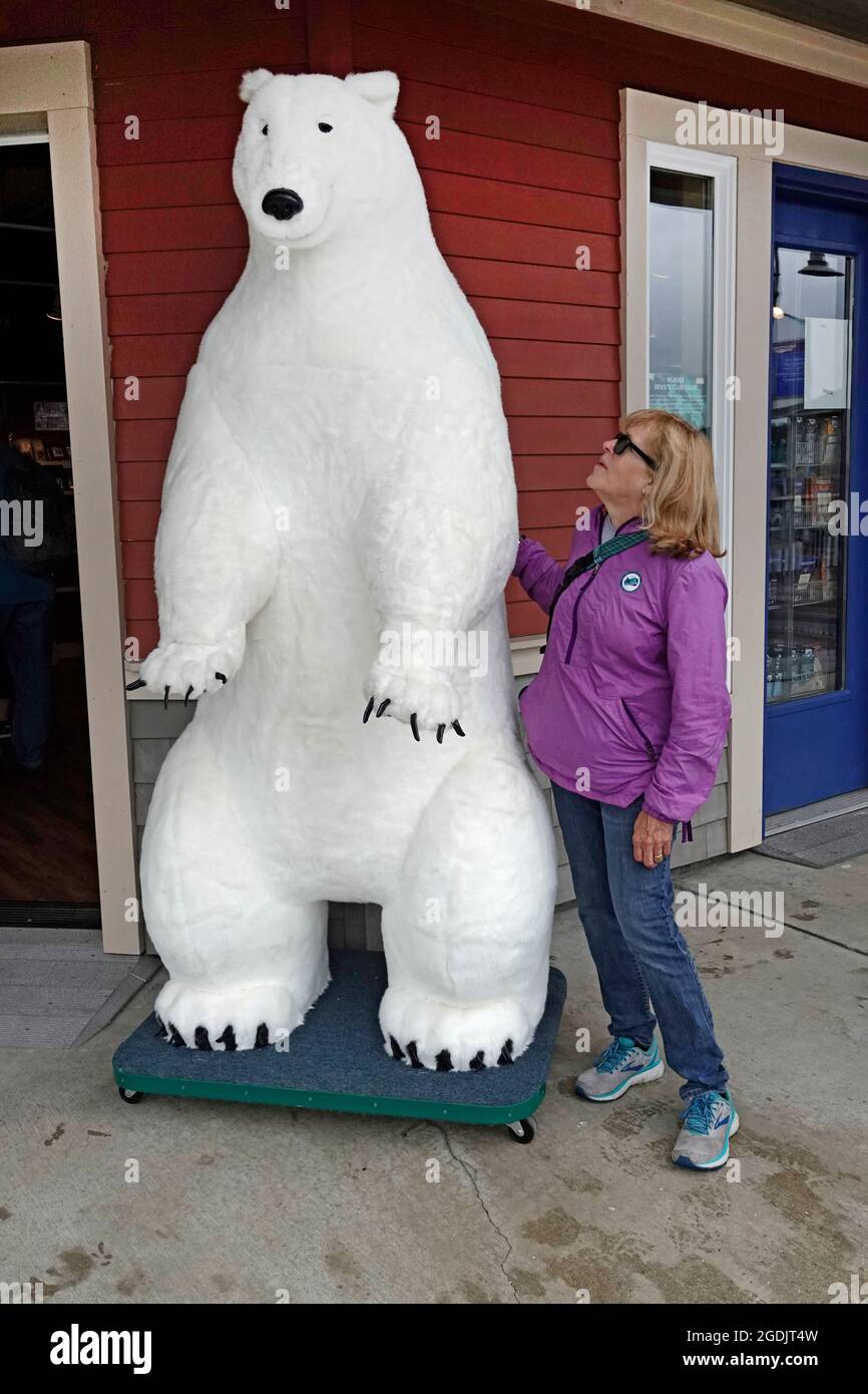 A tourist from a cruise ship browses merchandise at a local shop in Ketchikan, Alaska. This is a fake polar bear. Stock Photo