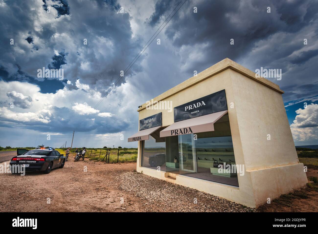 A Texas State Trooper talks with a motorcyclist near this Prada Marfa 'sculpture' designed to look like a Prada store located in Marfa, Texas northwes Stock Photo