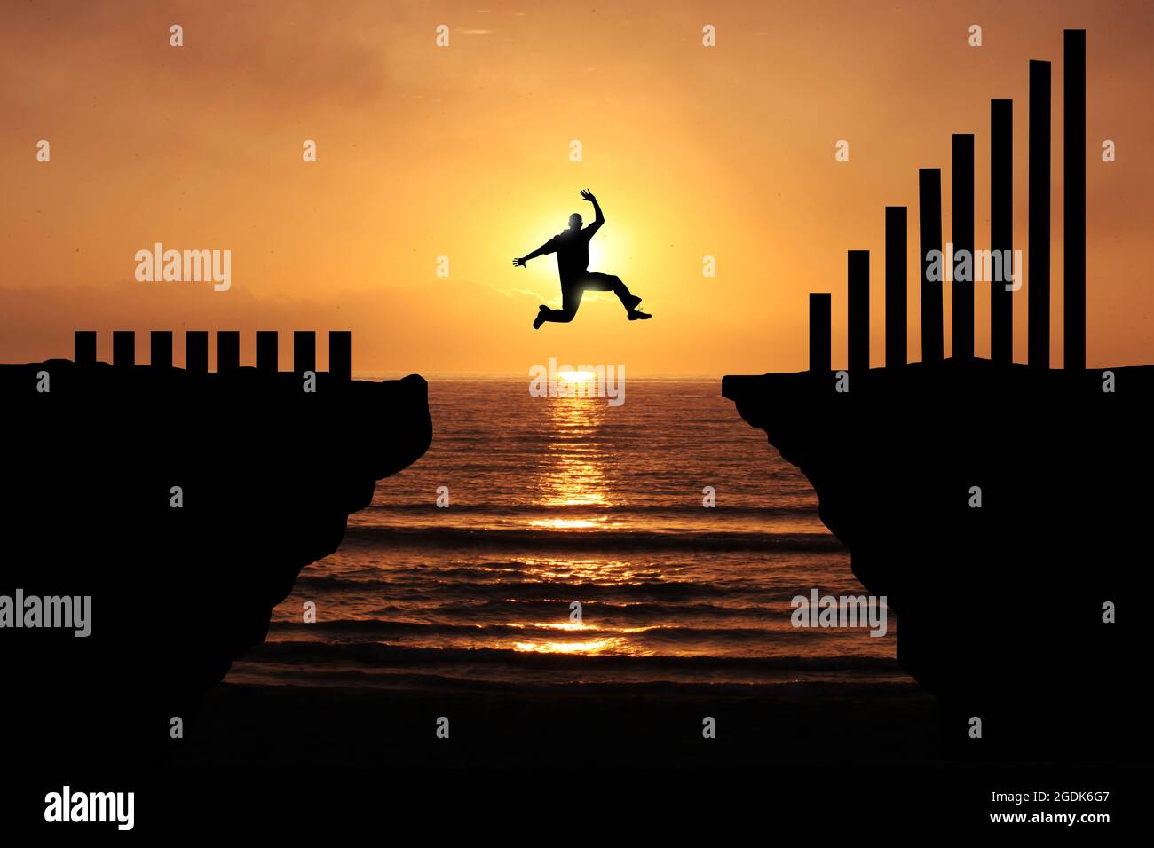 Increase earning and productivity By taking a big risk. Silhouette of a business man jumping over the cliff to attempt More profit and rise more. Stock Photo