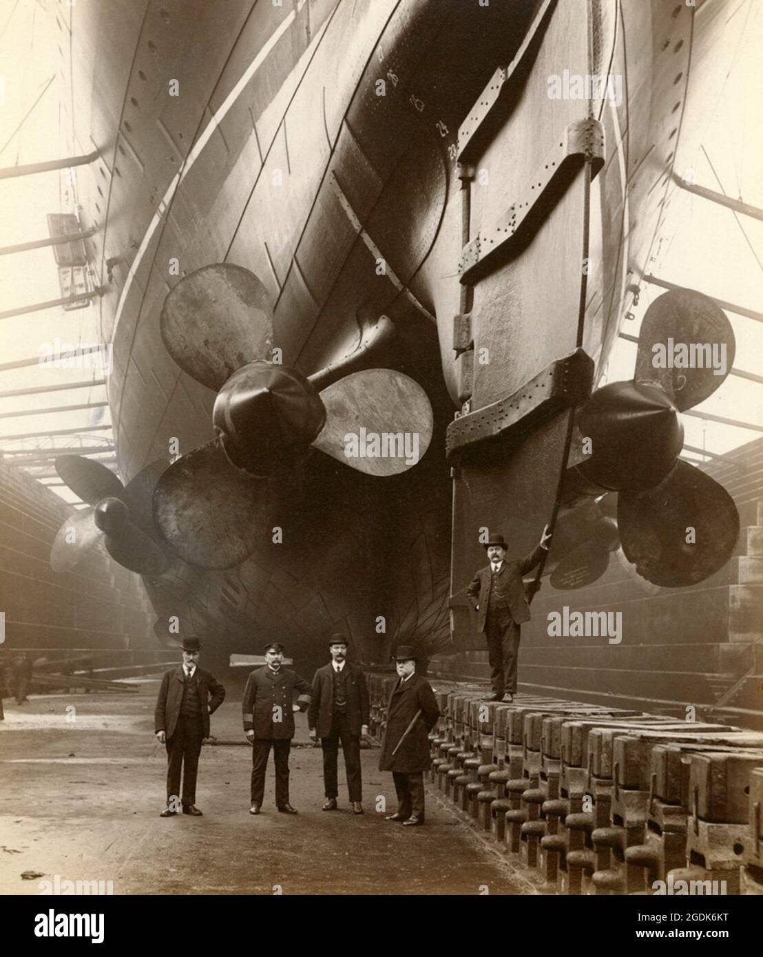 The massive stern and propellers of the RMS Mauretania, with human figures giving a sense of how big the ship is Stock Photo