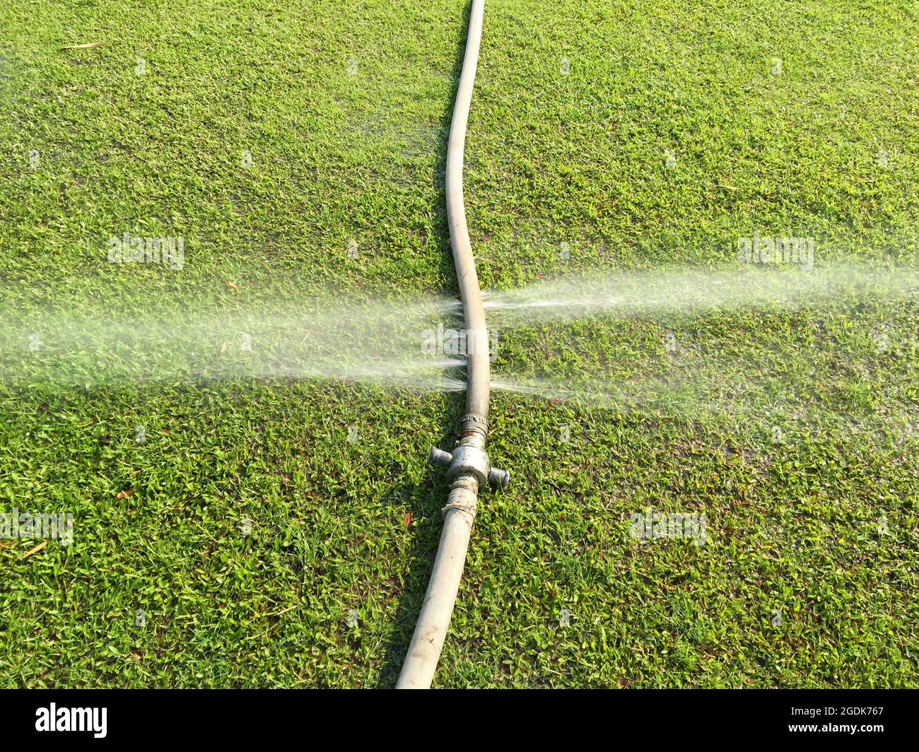 wasting water water leaking from hole in a hose Stock Photo Alamy