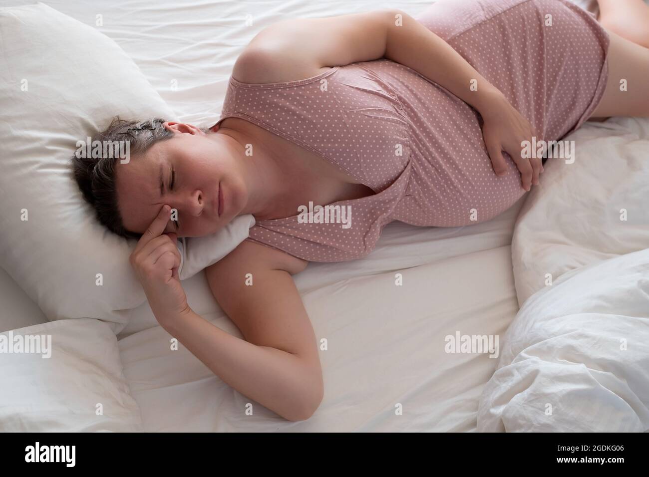 Worried pregnant woman in the bed suffering from insomnia Stock Photo