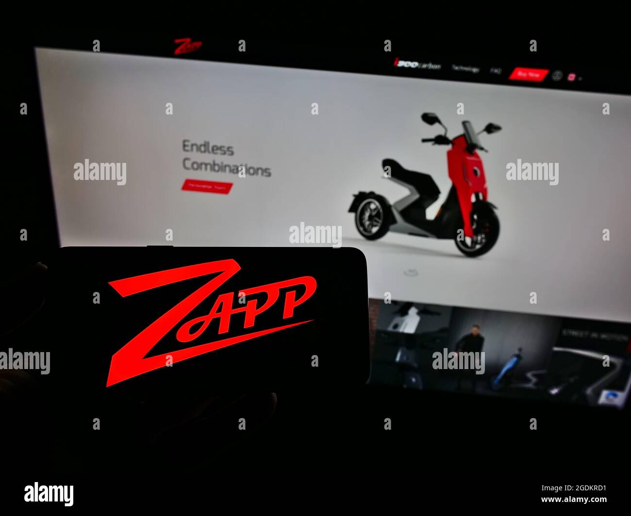 Person holding smartphone with logo of electric motorcycle company Zapp Scooters Ltd. on screen in front of website. Focus on phone display. Stock Photo