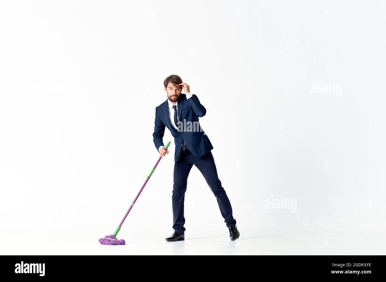 man in a suit with a mop in his hands emotions cleaning official Stock Photo