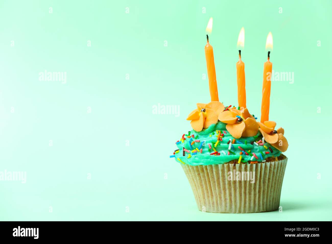 Delicious birthday cupcake on light green background Stock Photo Alamy