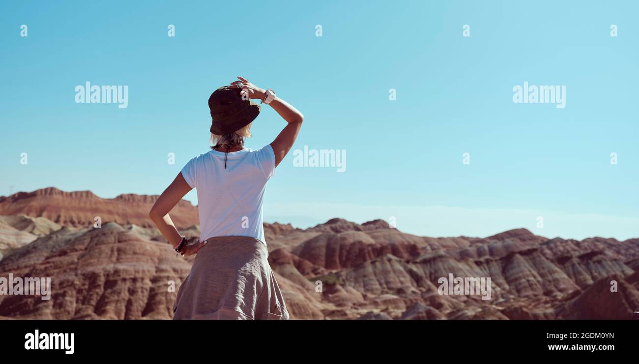 rear view of an asian woman tourist looking at the yardang landforms in national geological park Stock Photo