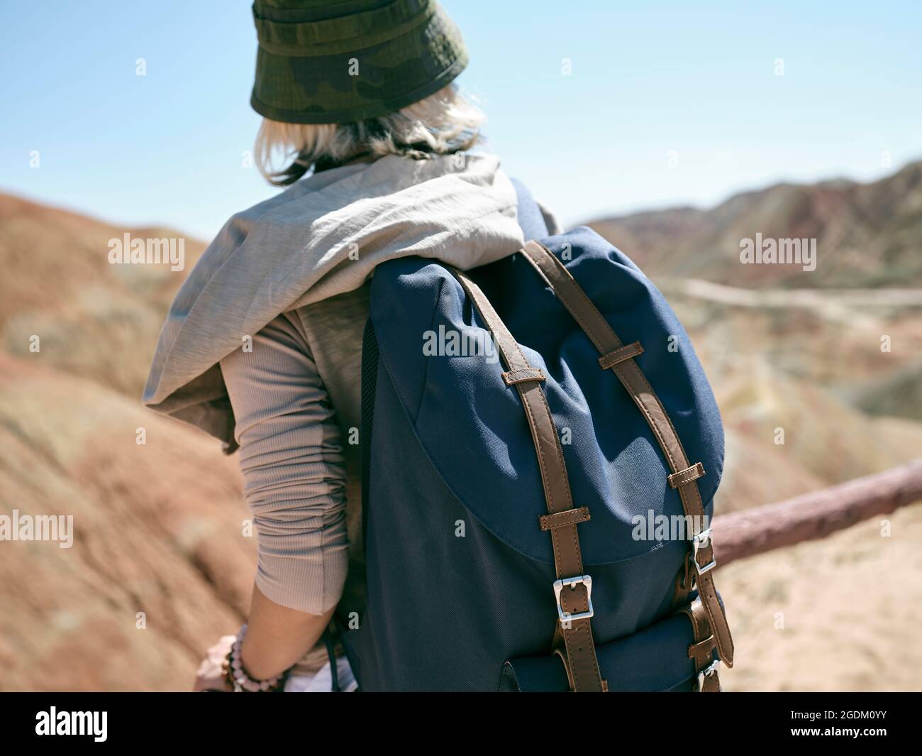 rear view of an asian woman female tourist backpacker looking at the yardang landforms in national geological park Stock Photo