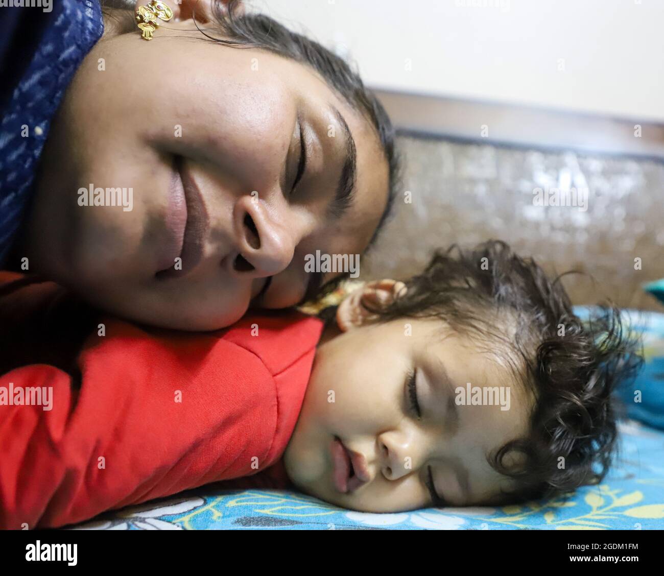 close up portrait of indian mother sleeping with her baby Stock Photo