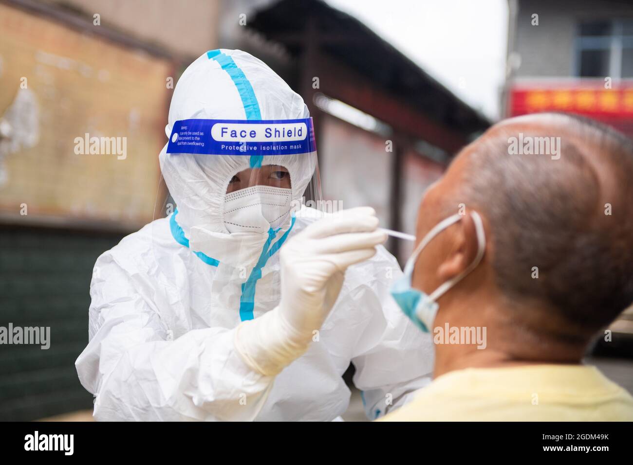 Zhangjiaje, China. 13th Aug, 2021. (210814) -- ZHANGJIAJIE, Aug. 14, 2021 (Xinhua) -- Luo Jinwu takes a throat swab sample from a resident for nucleic acid testing in Yangping Village of Yongding District in Zhangjiajie City, central China's Hunan Province, Aug. 12, 2021. Luo Jinwu and his wife Xiang Ka are medical workers from Zhangjiajie Hospital of Traditional Chinese Medicine. Since the recent resurgence of COVID-19 in Zhangjiajie from July 29, Luo has been conducting nucleic acid tests especially in the countryside, while Xiang has stationed in the hospital to attend to patients. Being ap Stock Photo