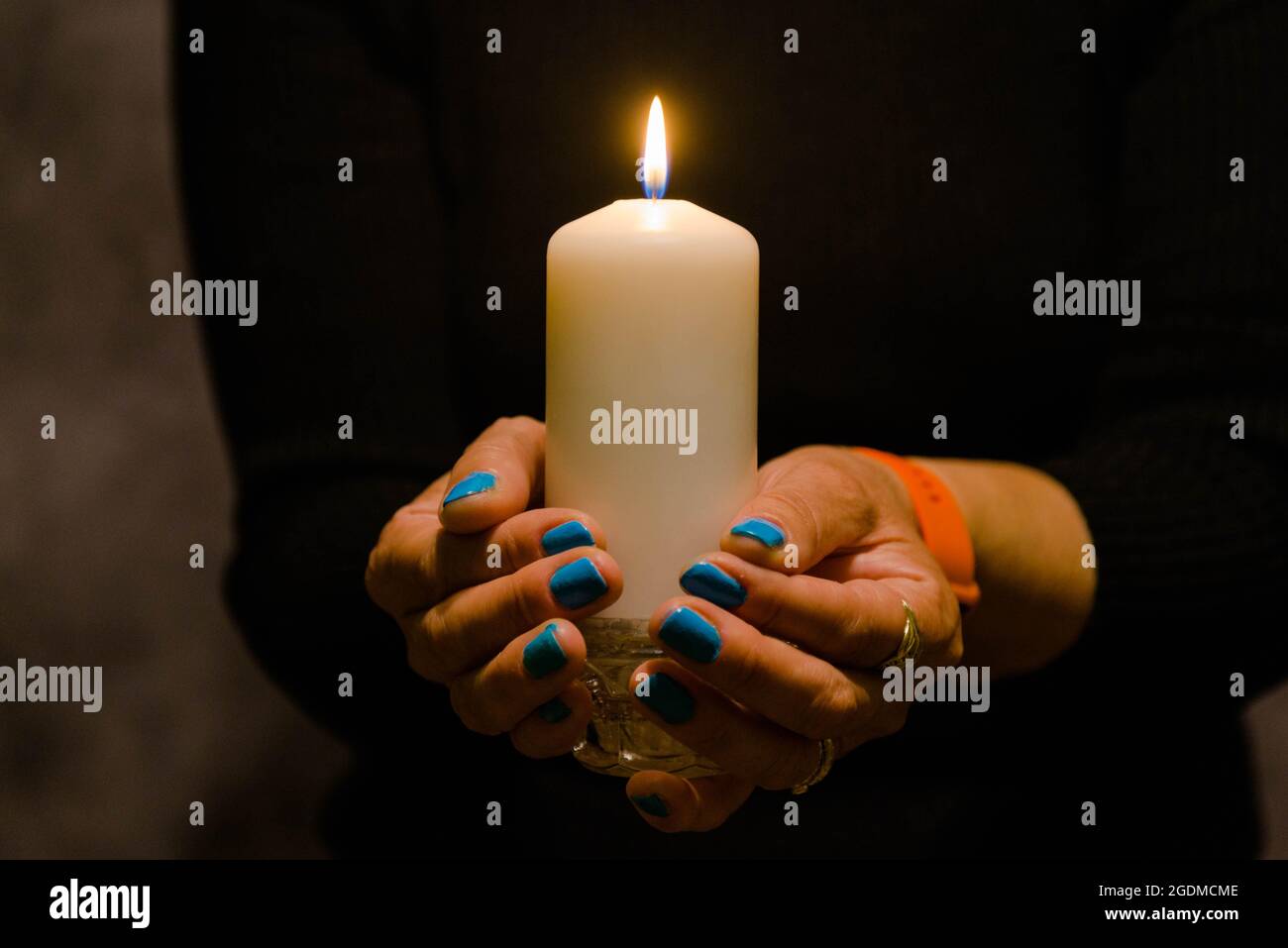 A burning white candle held in female hands Stock Photo Alamy