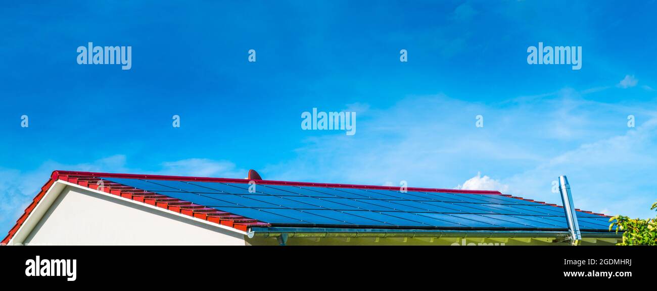 Solar panels on the red roof of a house generating clean electrical ...