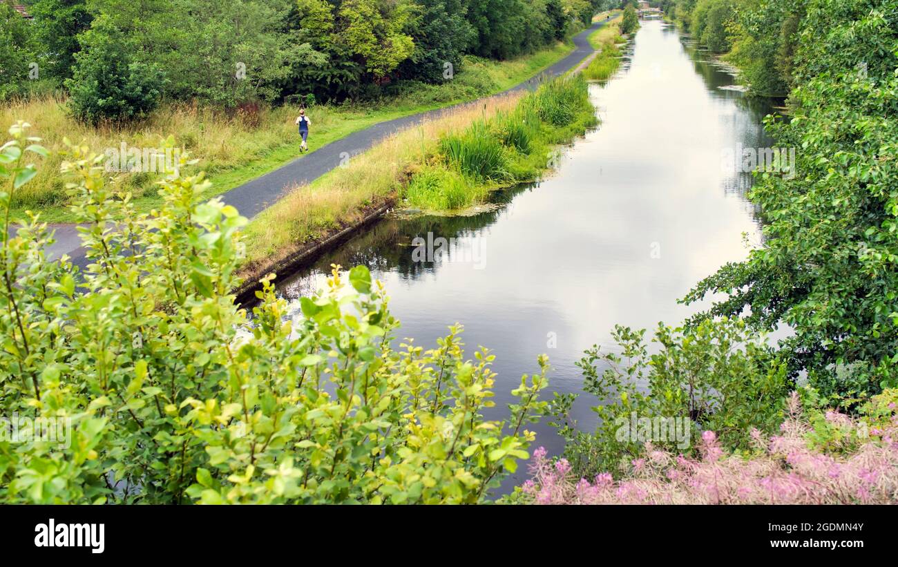 Glasgow, Scotland, 14th  August, 2021. UK  Weather:  Changable weather on the forth and clyde canal saw locals battle with intermittent rain as they exercised . Credit Gerard Ferry/Alamy Live News Stock Photo