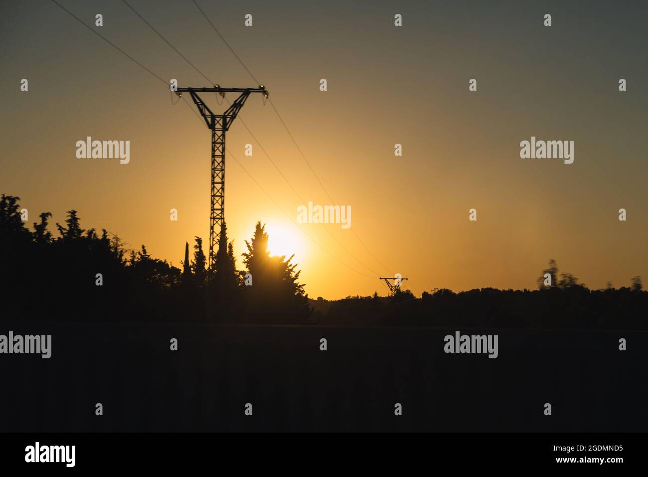 Silhouette of a high voltage electric tower in a sunset with selective ...