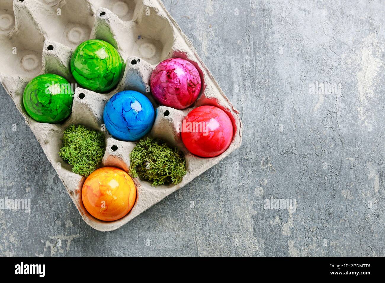 Paper box with Easter eggs on grey, stone background. Copy space. Stock Photo