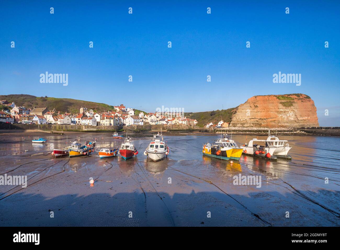 Fishing boats grounded at low tide in the harbour at Staithes, North Yorkshire. Stock Photo