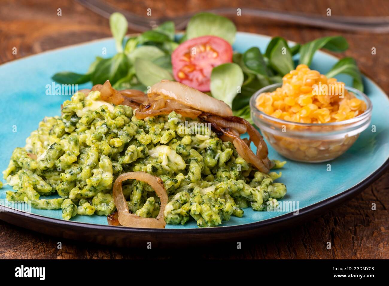 bavarian spinach spaetzle on a blue plate Stock Photo