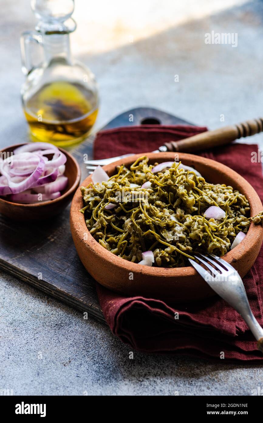 Traditional georgian fermented bladdernut blossom knows as a jonjoli, served in a bowl with red onion and oil Stock Photo