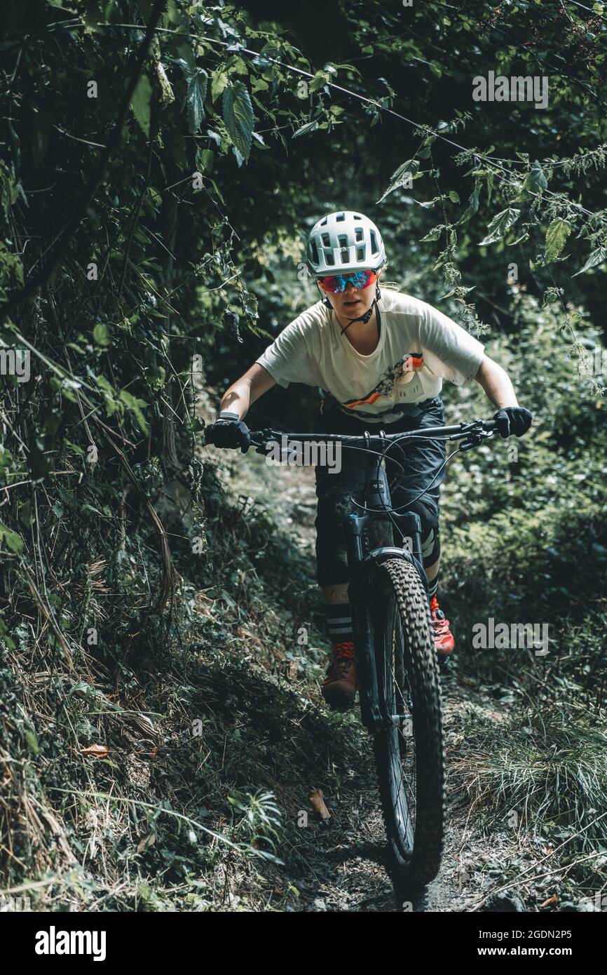 Portrait action shot of focussed female mountainbiker riding a trail Stock Photo