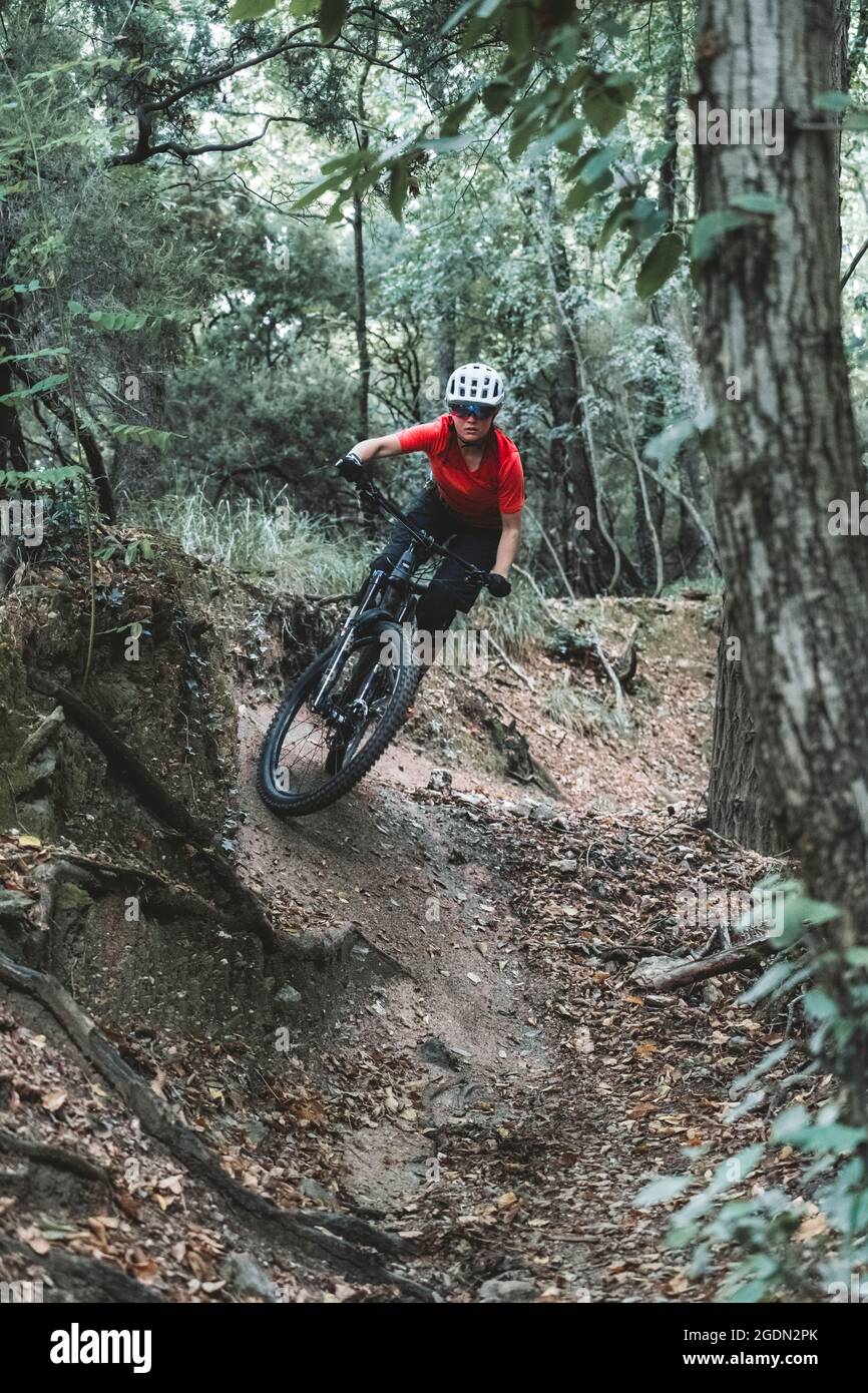 focussed female mountainbiker taking a corner on trail Stock Photo