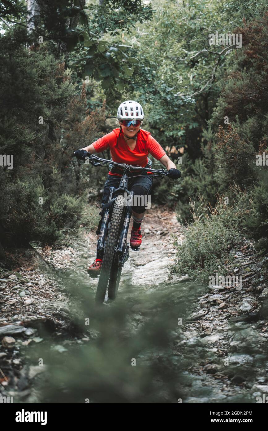 frame filling action portrait of young woman on Mountainbike on trail Stock Photo