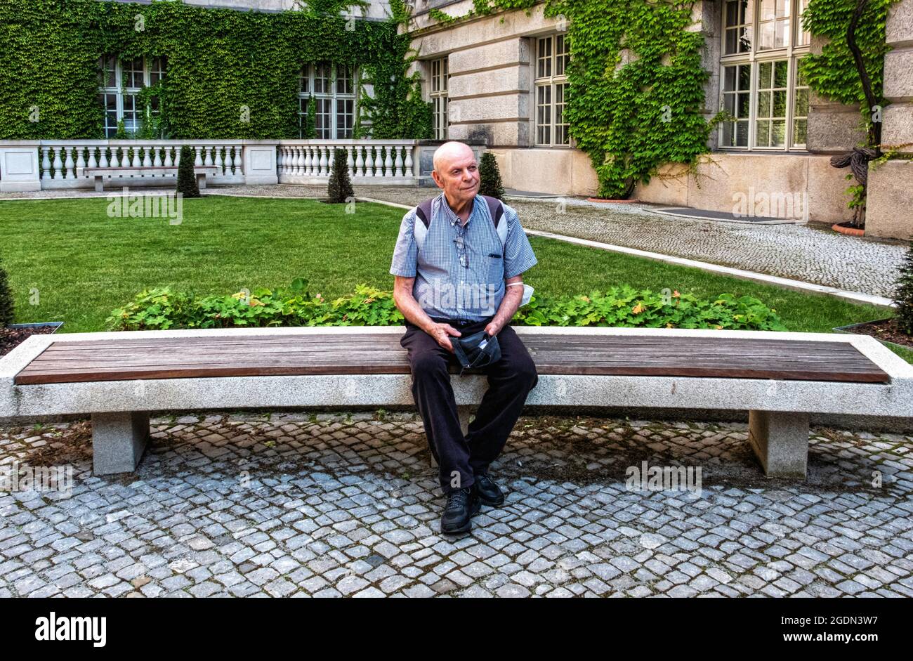 Berlin State Library – Elderly man sits on bench  in forecourt of largest academic research library in Germany, Unter den Linden 8,Mitte,Berlin  Desig Stock Photo