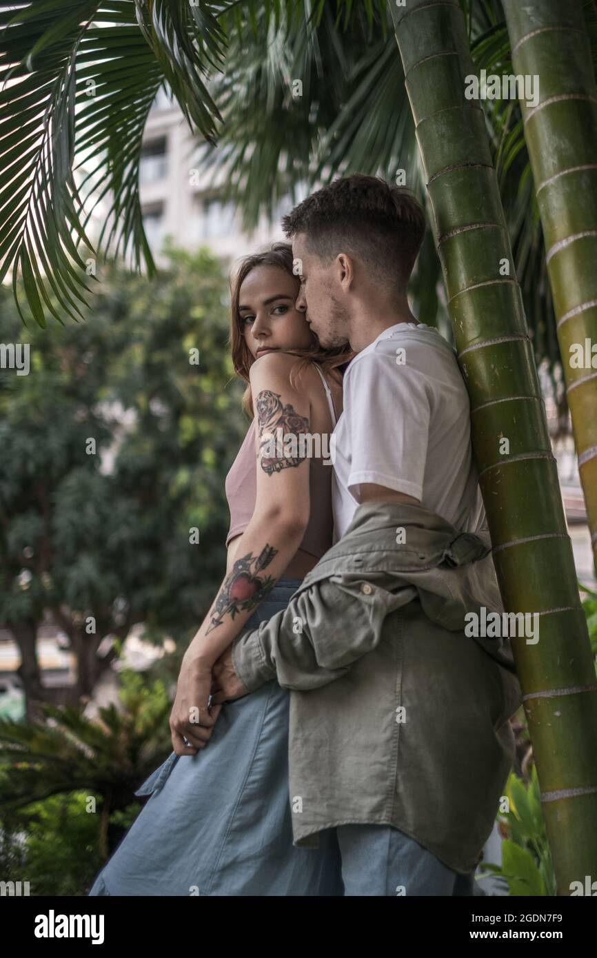 Portrait of loving couple cuddling in a park. Looking at camera with copy space. Wearing casual clothes. Stylish people. High quality photo  Stock Photo