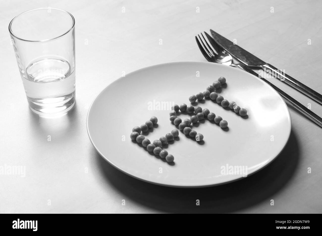 Anorexia. FAT spelt out with peas on a plate. Stock Photo