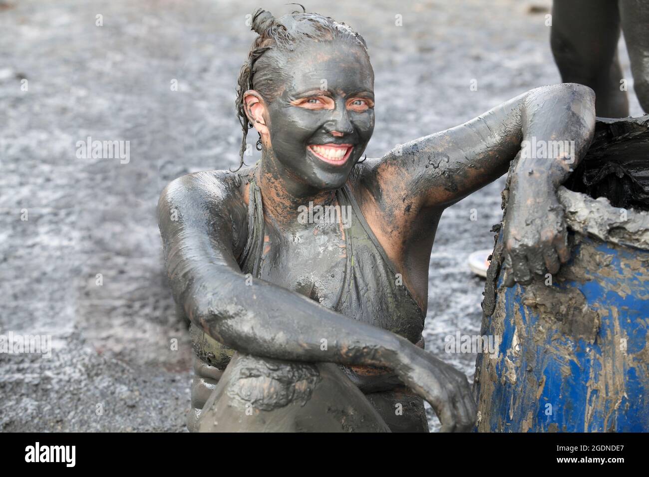 Israel, Dead Sea, tourist covers herself in therapeutic mud in order to benefit from claimed skin care properties of this mud. (Model Release Availabl Stock Photo