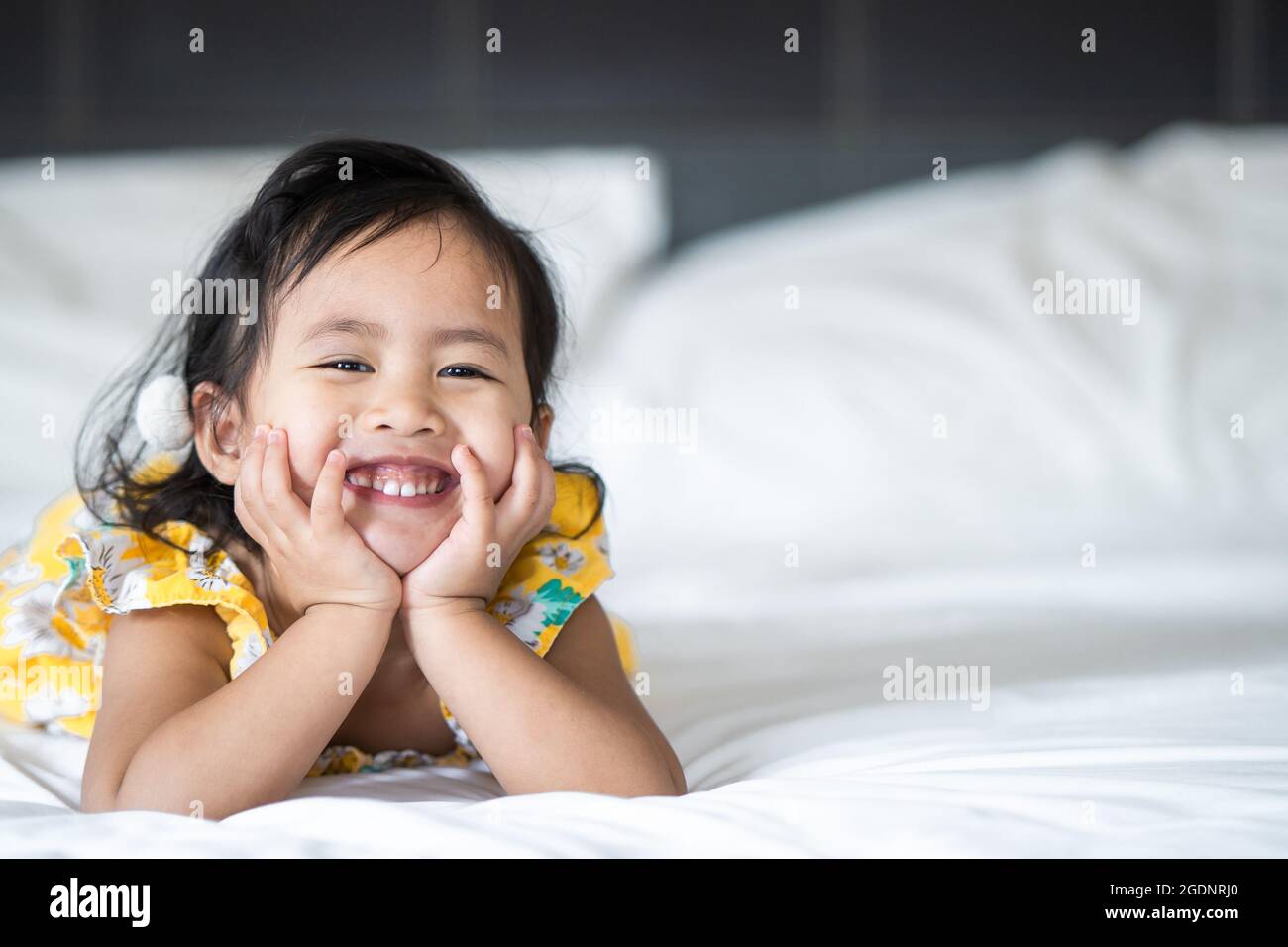 Asian cheerful little girl lying on her bed ind Stock Photo - Alamy