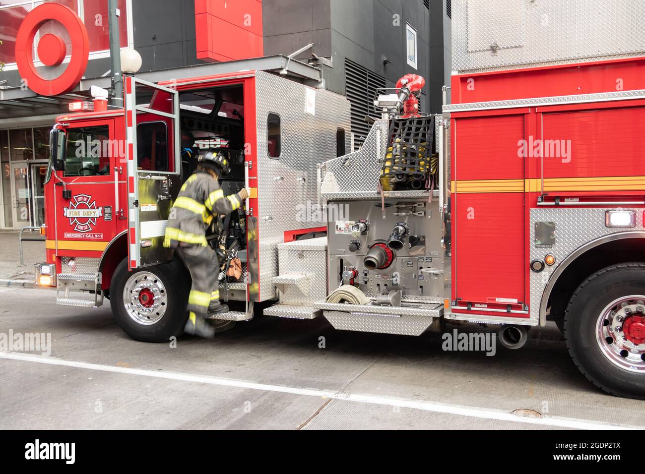 fire fighter entering fire truck called to a trash bin fire in Seattle, USA Stock Photo