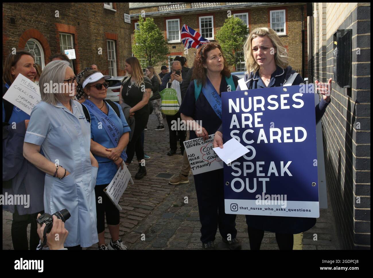 London, UK. 12th May, 2021. Health professionals and their supporters join nurse Jenna Platt outside the Nurses Midwifery Council.Jenna is currently walking around the UK wearing a sandwich board that encourages debate, visiting all 69 cities to highlight how Covid care has left nurses unhappy and too scared to question policy for fear of losing their jobs. Some health workers have spoken of bullying, coercion and being ostracised. Many feel if they ask questions, they are seen as being part of the problem. Jenna delivered a letter of complaint to The Nursing Midwifery Council in Lo Stock Photo
