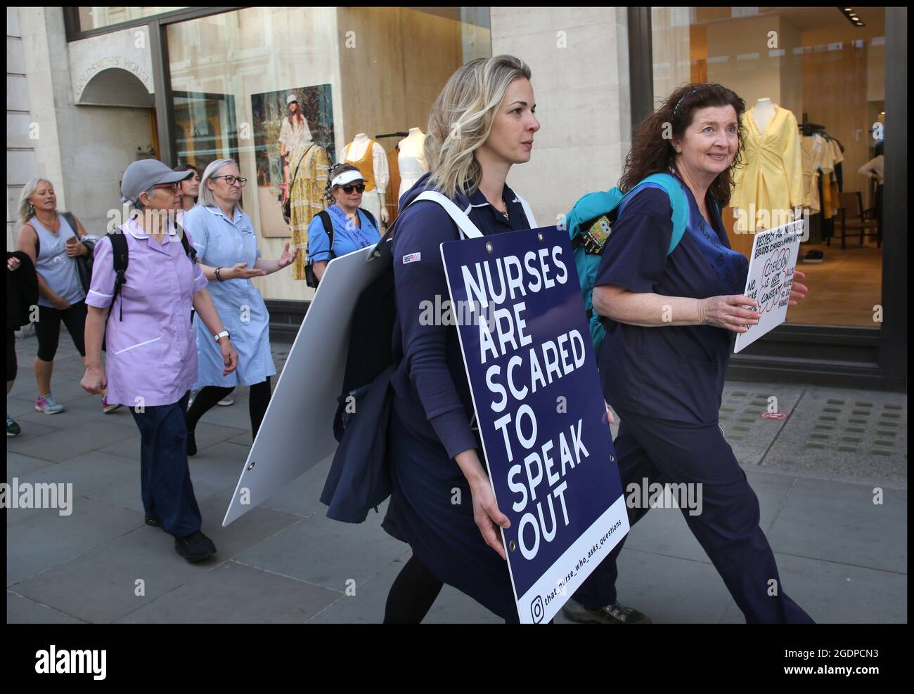 London, UK. 12th May, 2021. Health professionals and their supporters join nurse Jenna Platt along Regent's Street enroute to the Nurses Midwifery Council.Jenna is currently walking around the UK wearing a sandwich board that encourages debate, visiting all 69 cities to highlight how Covid care has left nurses unhappy and too scared to question policy for fear of losing their jobs. Some health workers have spoken of bullying, coercion and being ostracised. Many feel if they ask questions, they are seen as being part of the problem. Jenna delivered a letter of complaint to The Nursin Stock Photo